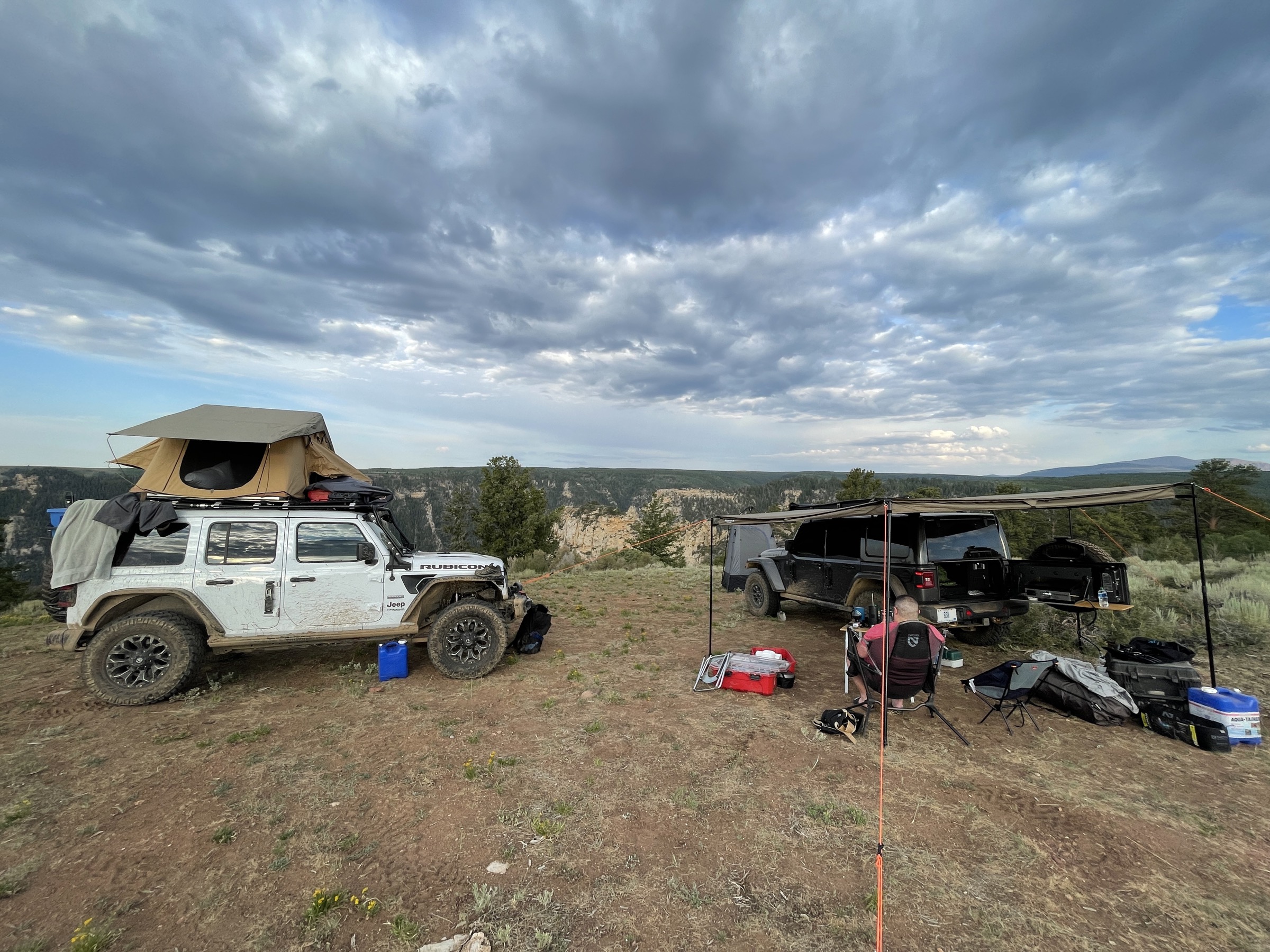 A Jeep and a Gladiator parked at a dramatic canyon rim